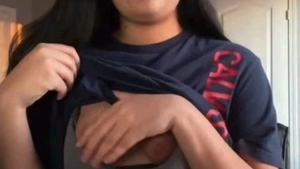 A stunning girl with Eastern features proudly displays her attractive breasts
