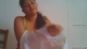 A lovely woman with natural breasts dresses in front of the camera