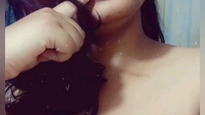 A stunning woman with enormous breasts indulges in self-pleasure